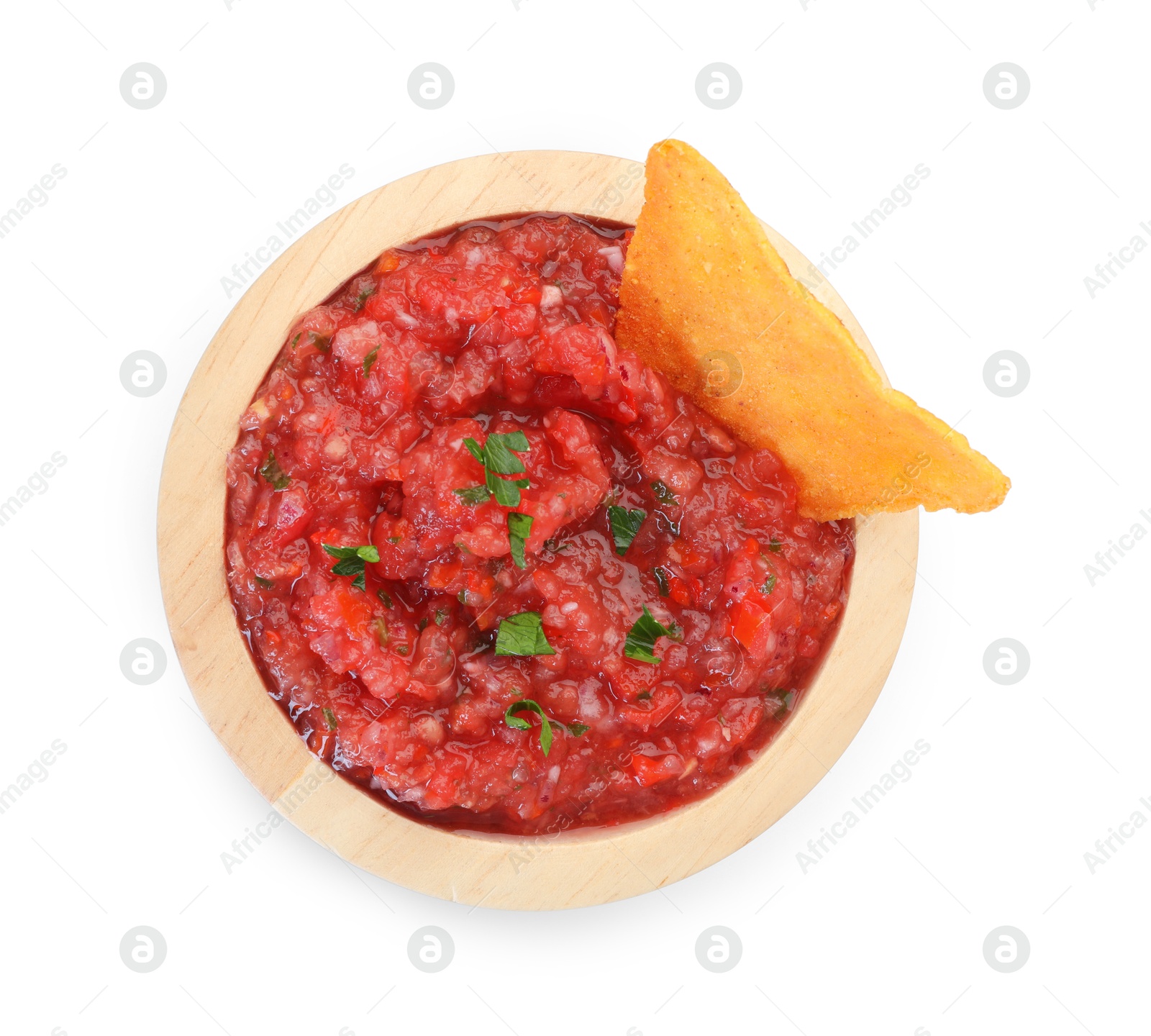 Photo of Spicy salsa sauce in bowl and nacho chip isolated on white, top view