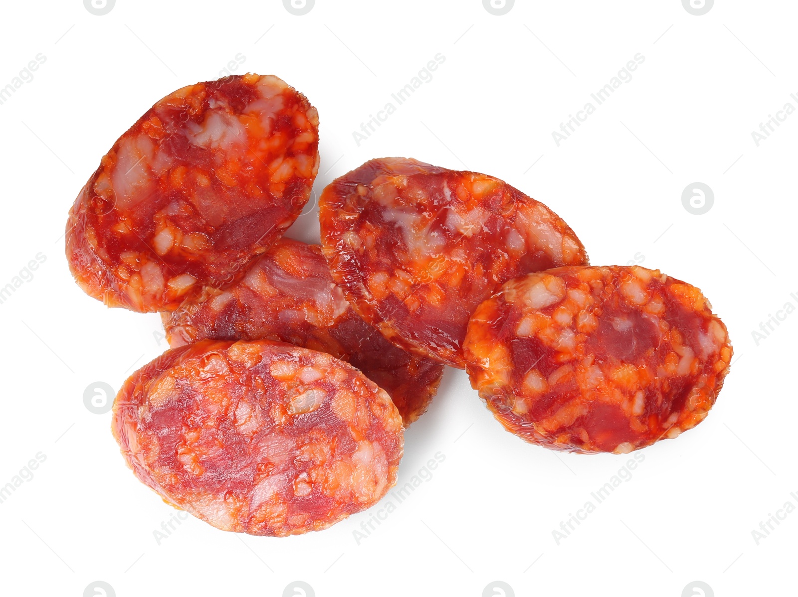 Photo of Pieces of delicious dry cured sausage isolated on white, top view