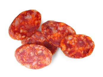 Photo of Pieces of delicious dry cured sausage isolated on white, top view