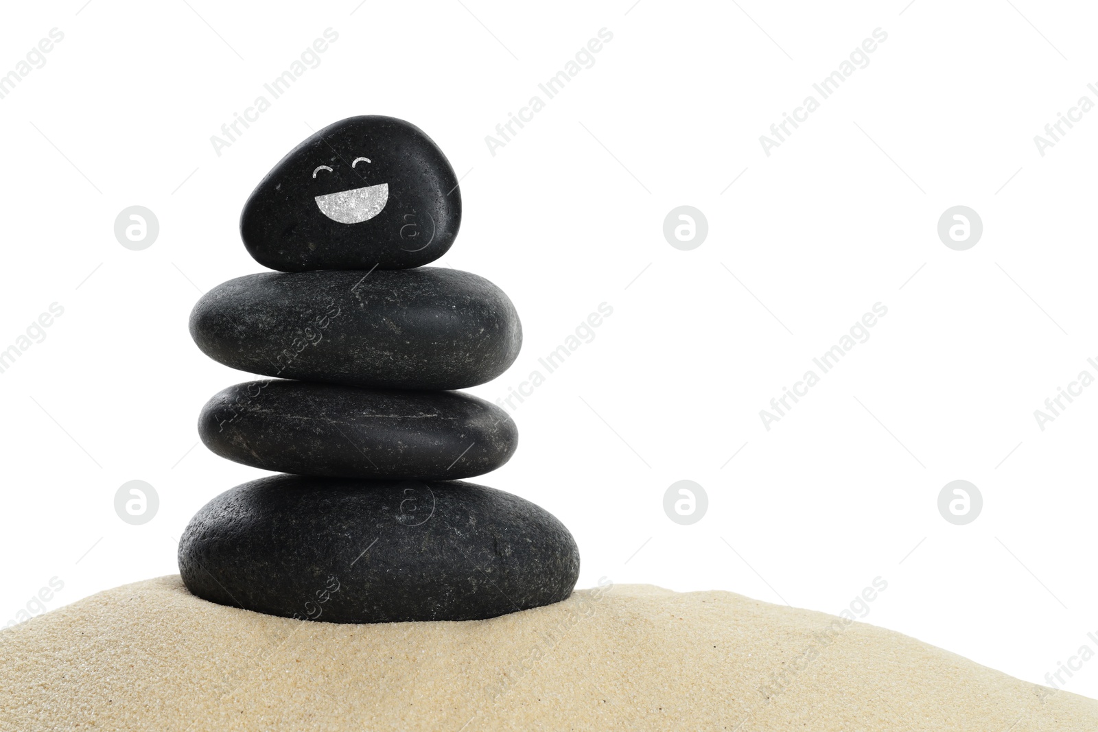 Photo of Stack of stones with drawn smiley face on sand against white background. Harmony and life balance