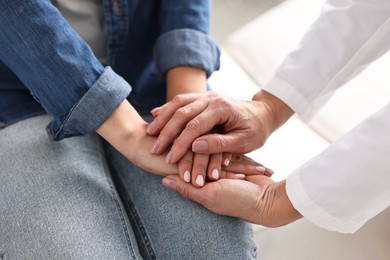 Photo of Doctor supporting patient during appointment in hospital, closeup of hands