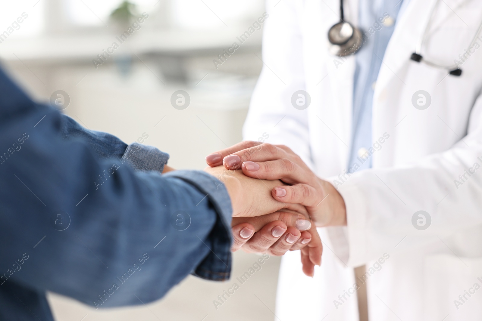 Photo of Doctor supporting patient during appointment in hospital, closeup of hands