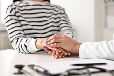 Photo of Doctor supporting patient during appointment in hospital, closeup of hands