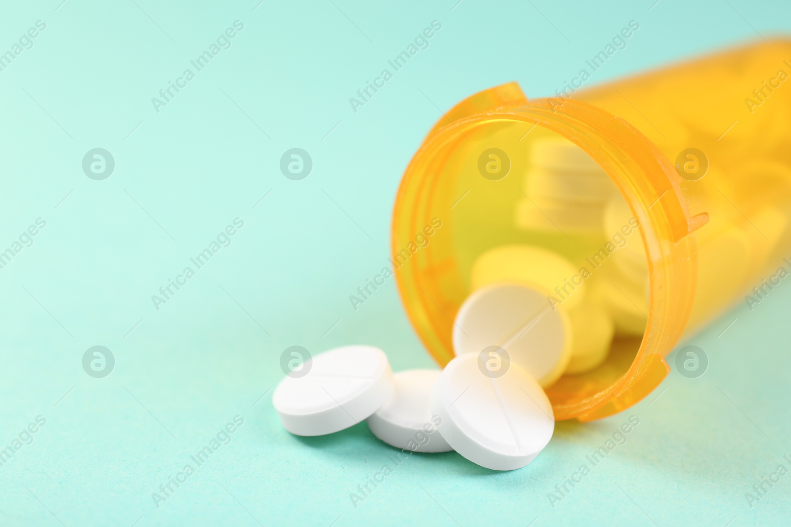 Photo of Medical bottle with antibiotic pills on yellow background, closeup. Space for text