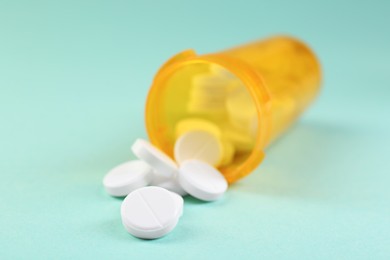 Photo of Medical bottle with antibiotic pills on yellow background, closeup