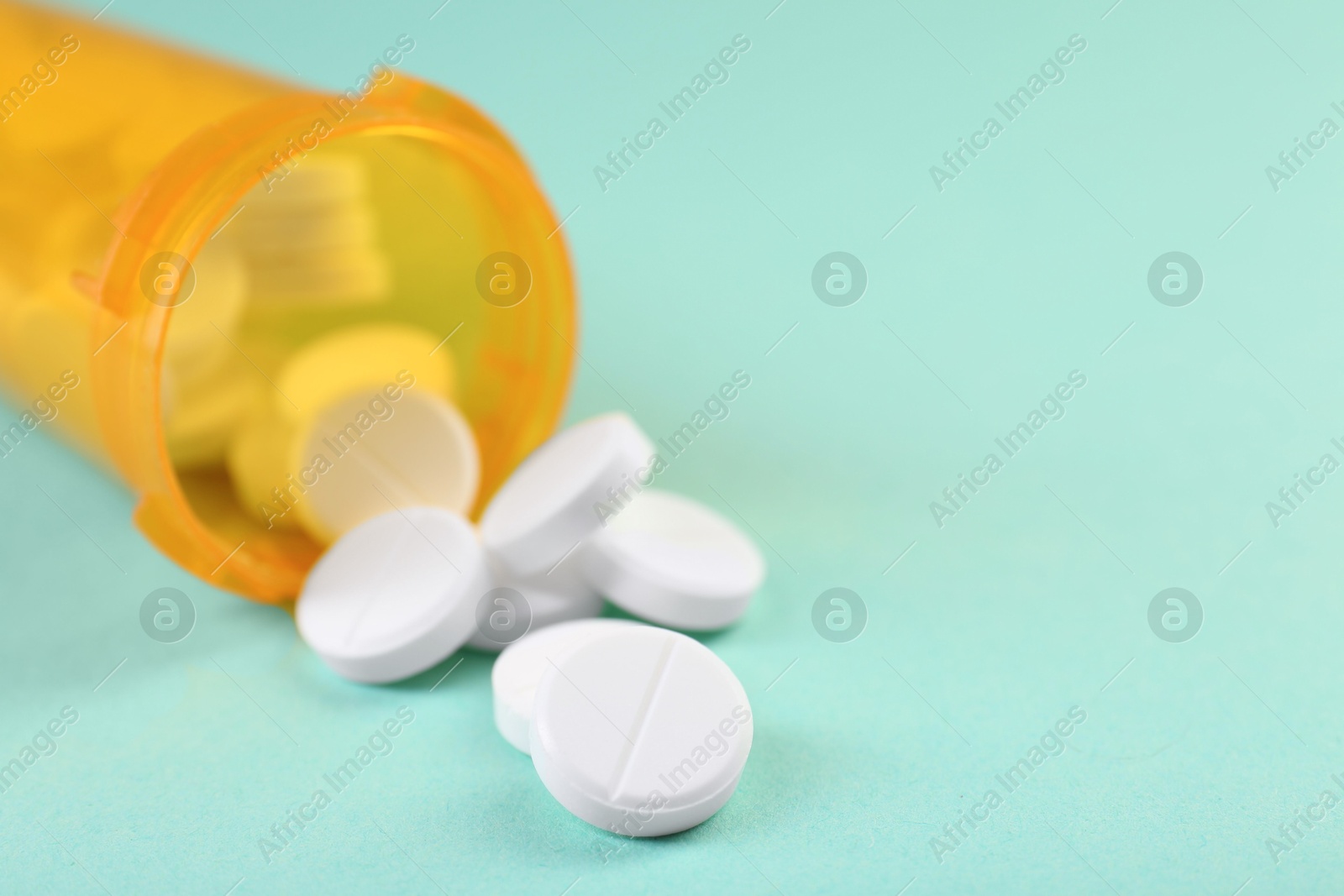 Photo of Medical bottle with antibiotic pills on yellow background, closeup. Space for text