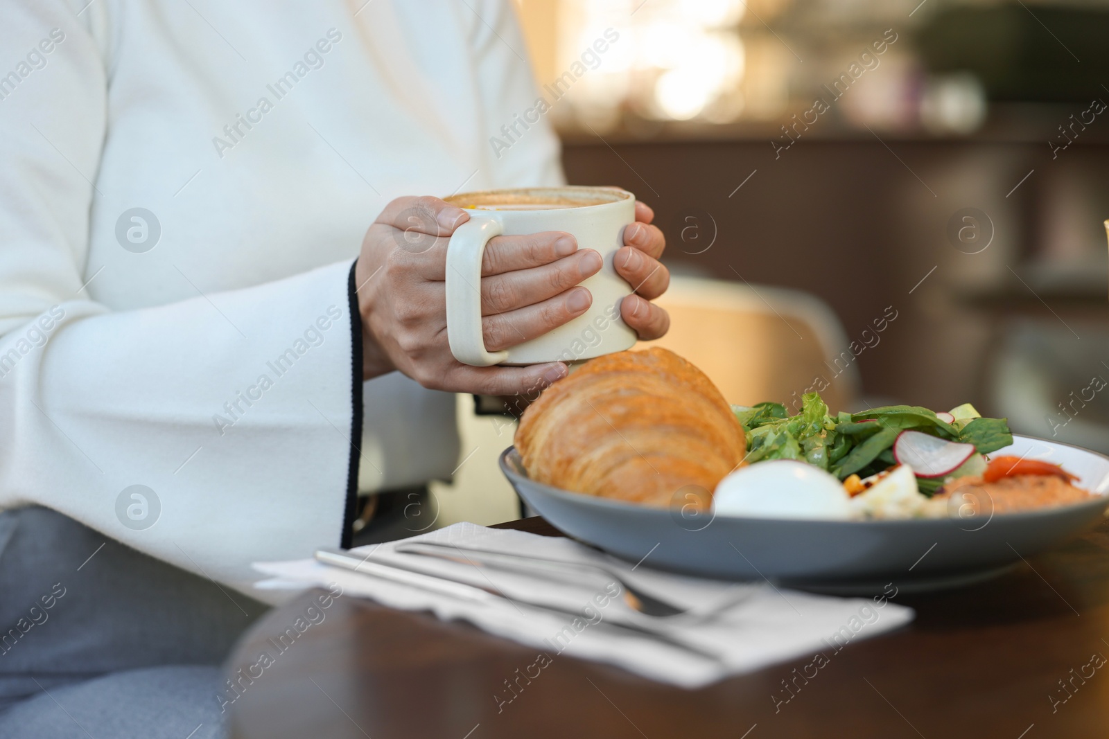 Photo of Woman having tasty breakfast in cafe, closeup