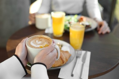 Photo of Women having tasty breakfast in cafe, closeup