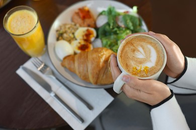 Photo of Woman having tasty breakfast in cafe, closeup