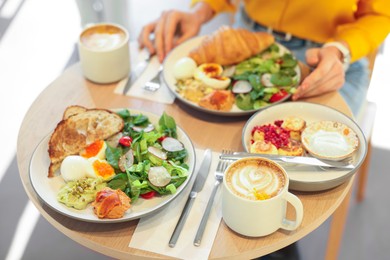 Photo of Woman having tasty breakfast in cafe, closeup