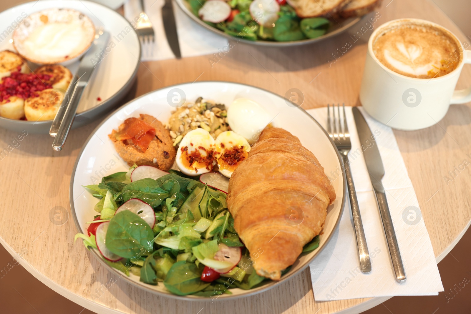 Photo of Tasty breakfast. Different meals and coffee served on wooden table in cafe, closeup