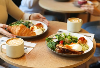 Photo of Woman having tasty breakfast in cafe, closeup