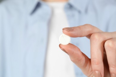 Photo of Woman holding antibiotic pill, closeup. Selective focus