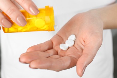 Photo of Woman with bottle of antibiotic pills, closeup