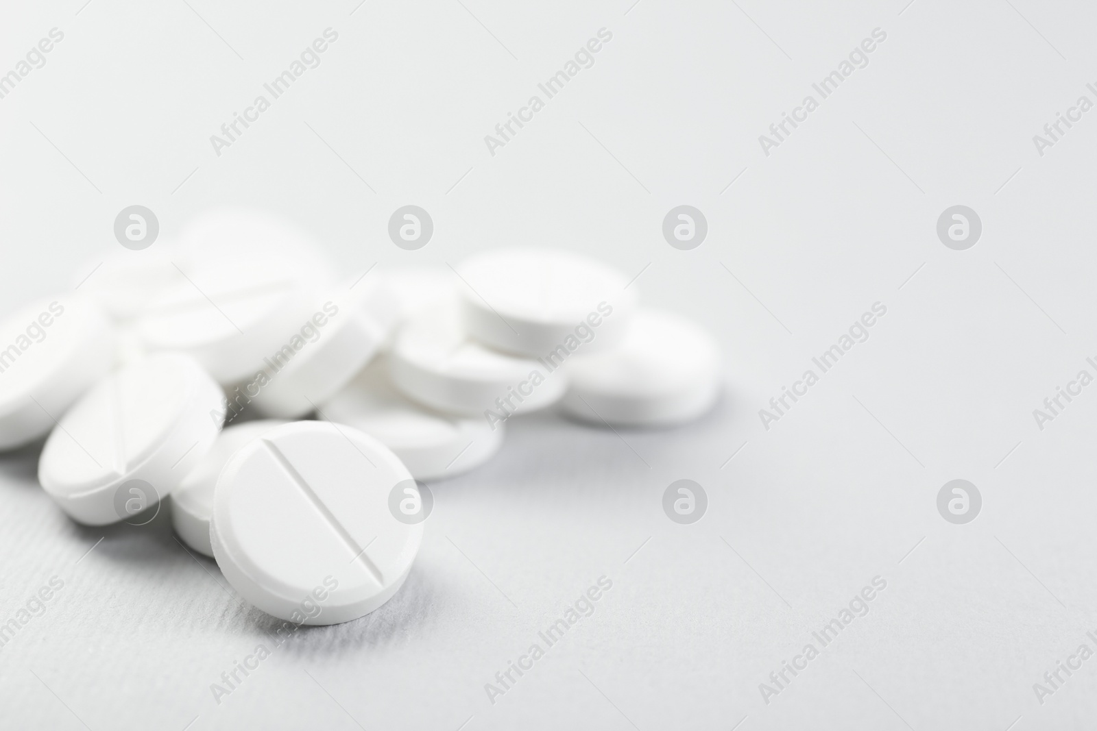 Photo of Pile of antibiotic pills on grey background, closeup. Space for text