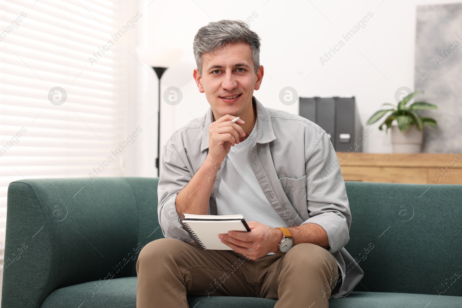 Photo of Portrait of professional psychologist with notebook in office