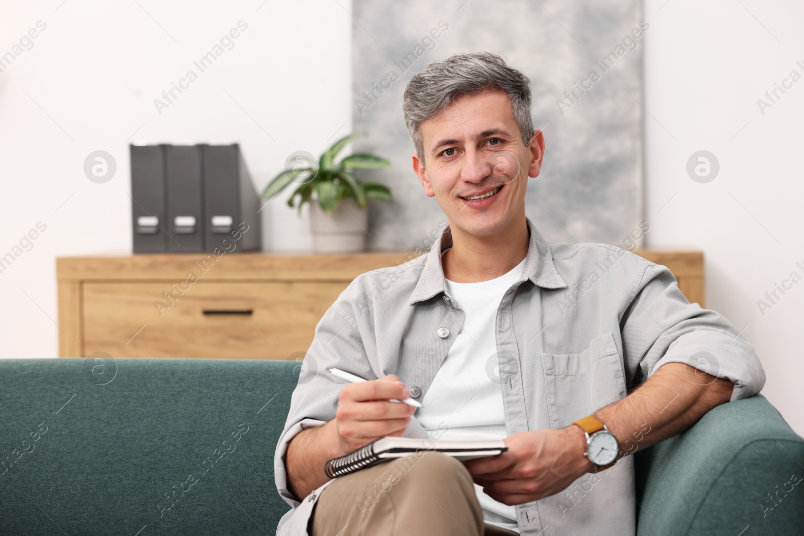 Photo of Portrait of professional psychologist with notebook in office, space for text