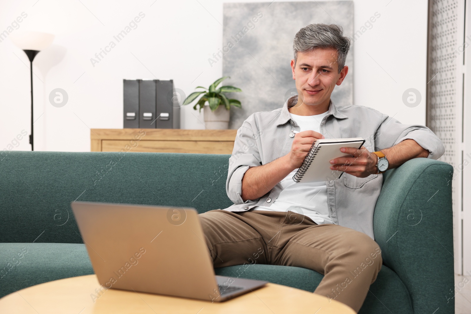 Photo of Professional psychologist working with laptop and notebook in office