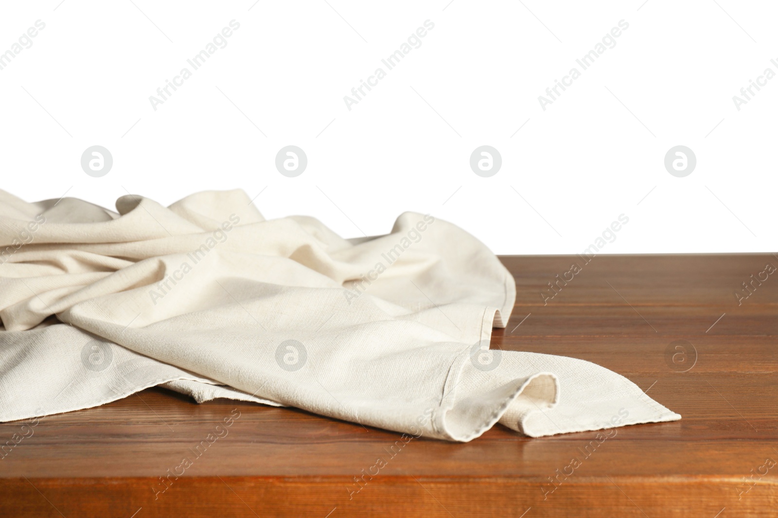 Photo of Light tablecloth on wooden table against white background, closeup