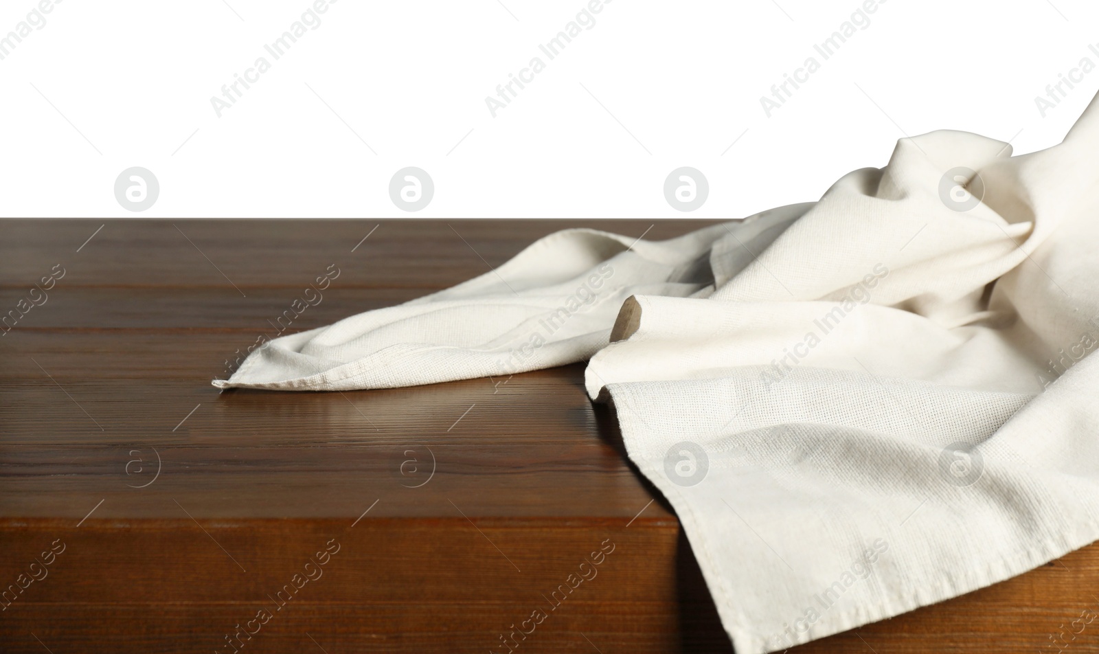 Photo of Light tablecloth on wooden table against white background, closeup