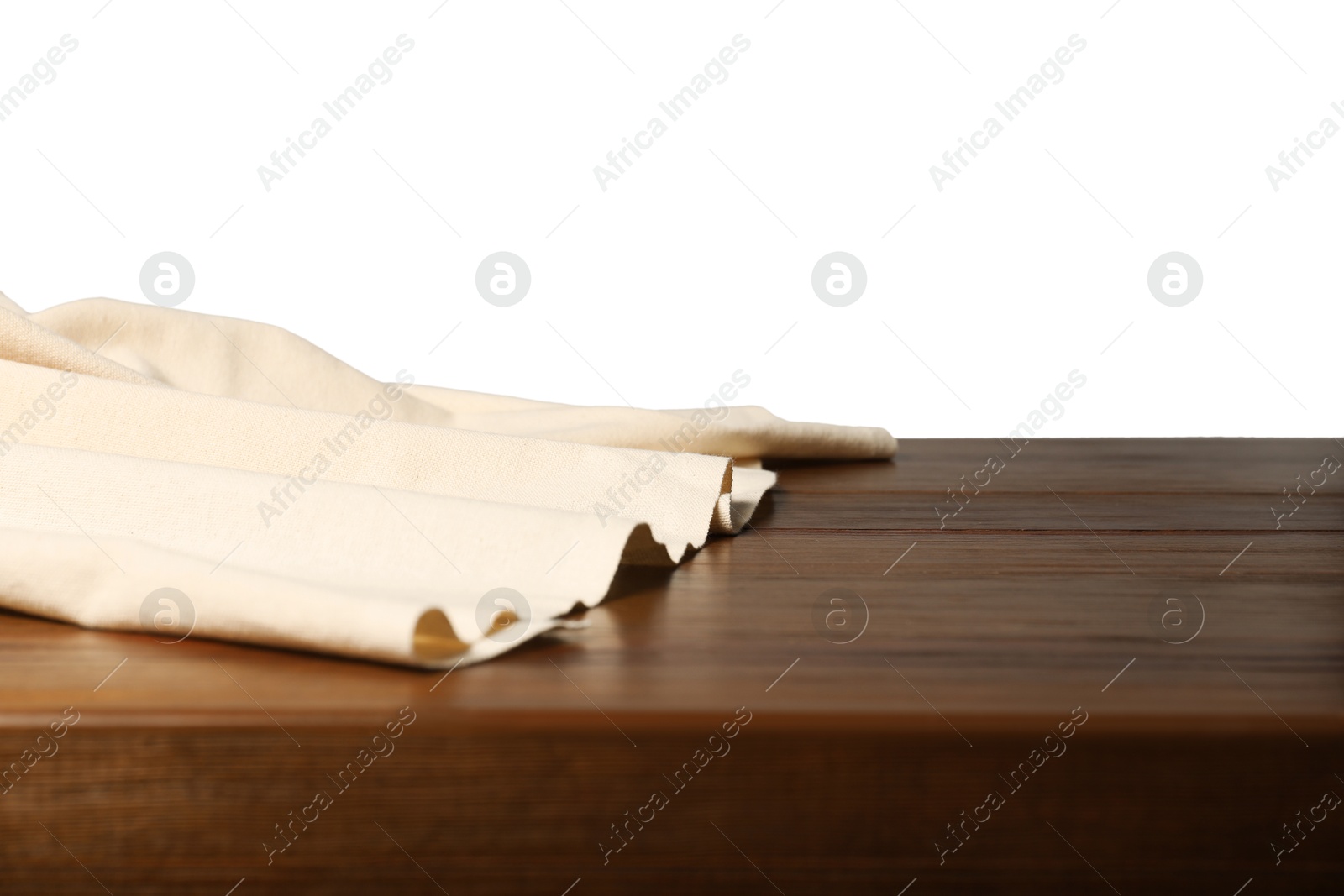 Photo of Beige tablecloth on wooden table against white background, closeup