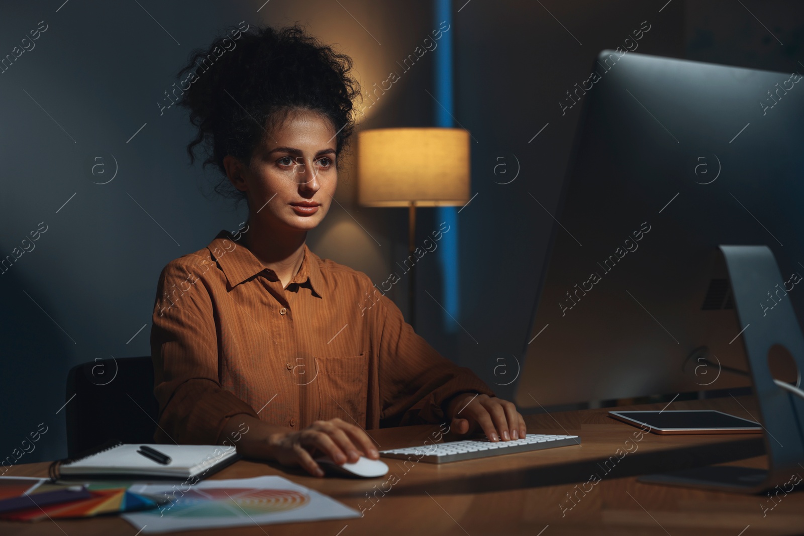 Photo of Designer working on computer indoors at night