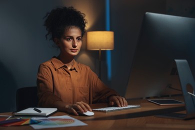 Photo of Designer working on computer indoors at night