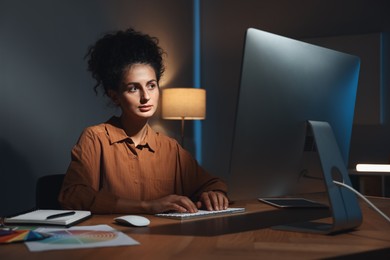 Photo of Designer working on computer indoors at night