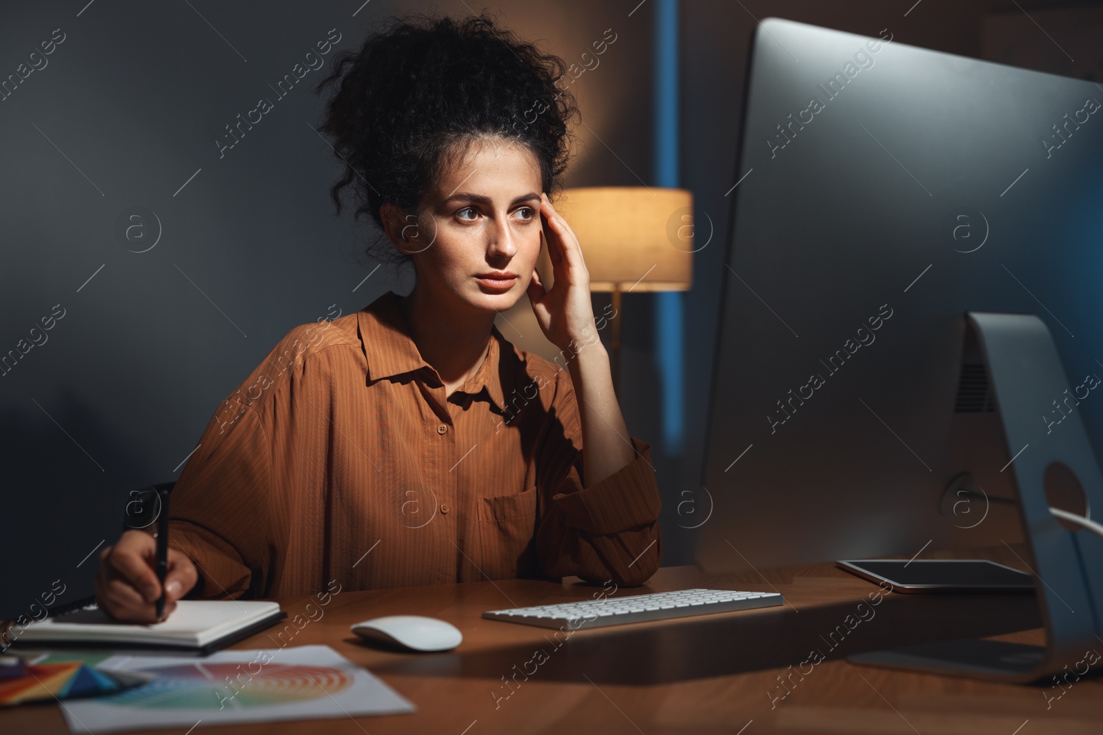 Photo of Designer working on computer indoors at night