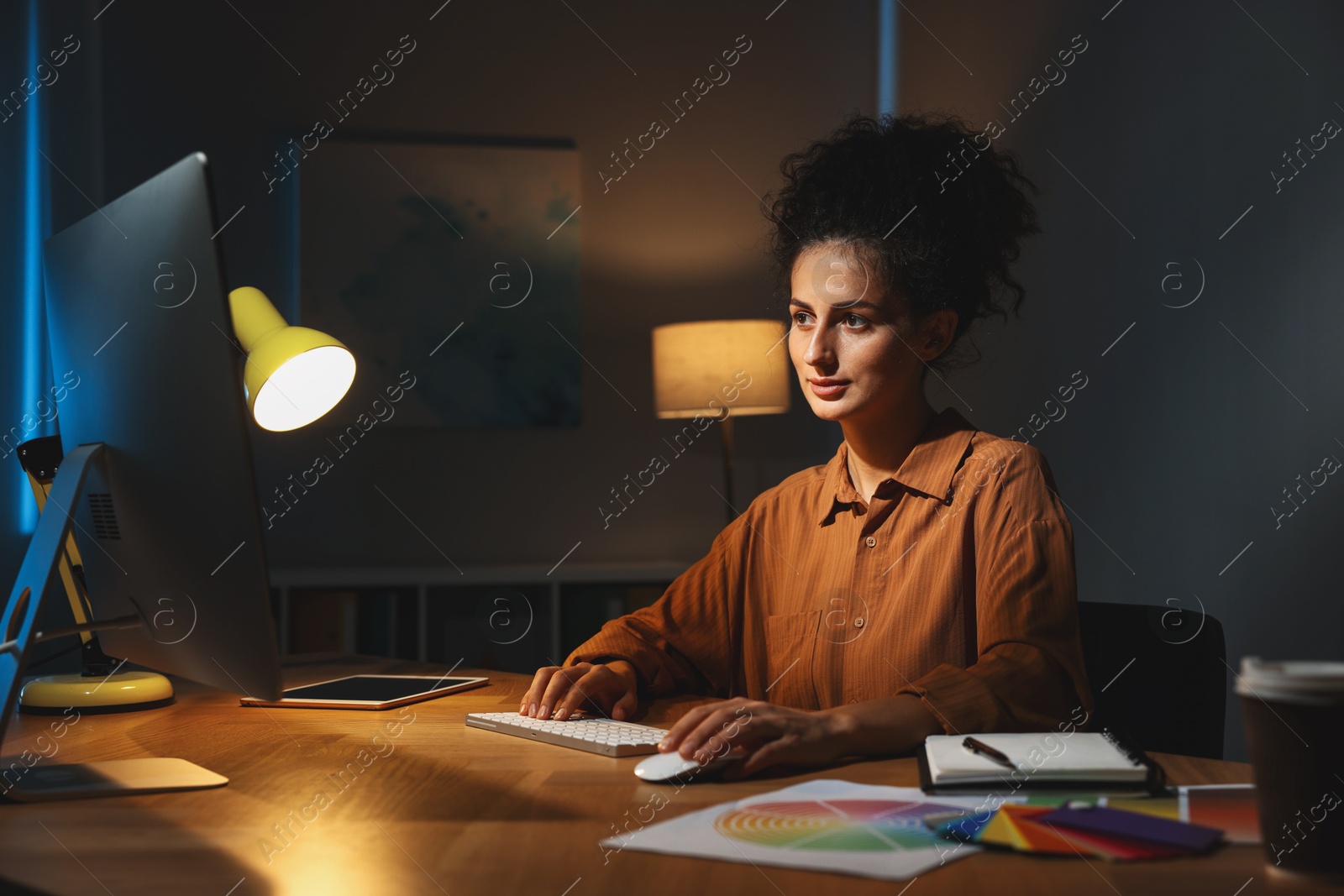 Photo of Designer working on computer indoors at night