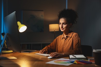 Photo of Designer working on computer indoors at night