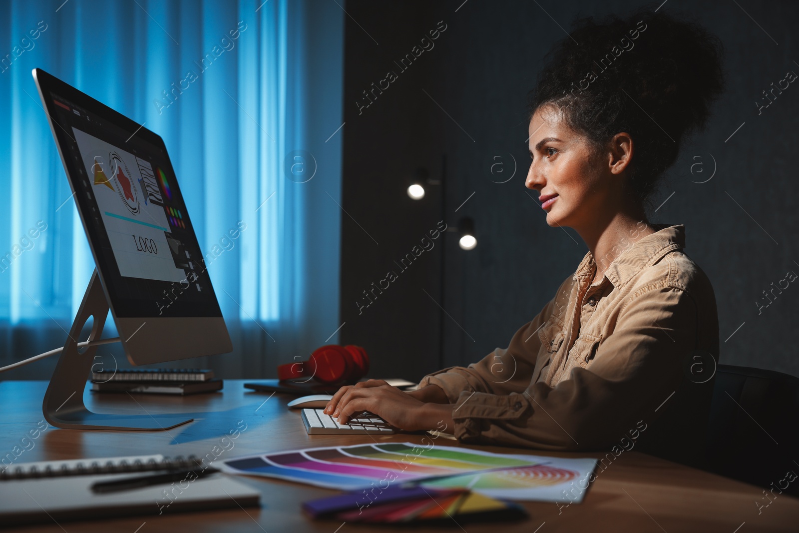 Photo of Designer working on computer indoors at night