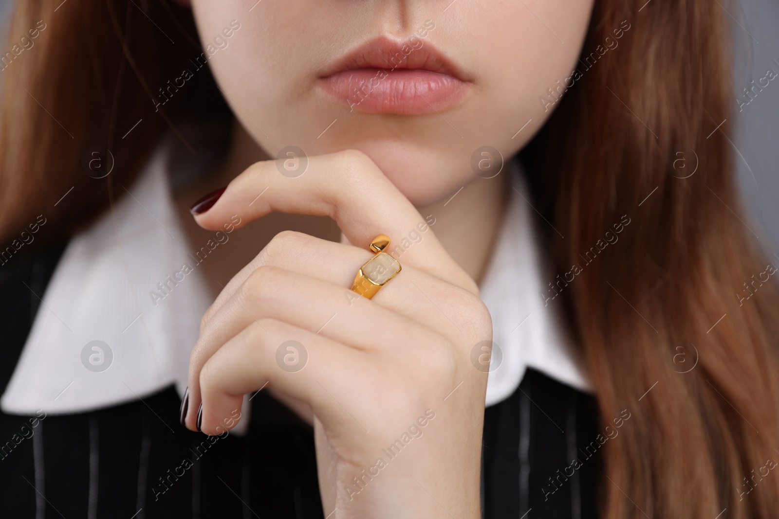 Photo of Teenage girl wearing stylish ring on grey background, closeup