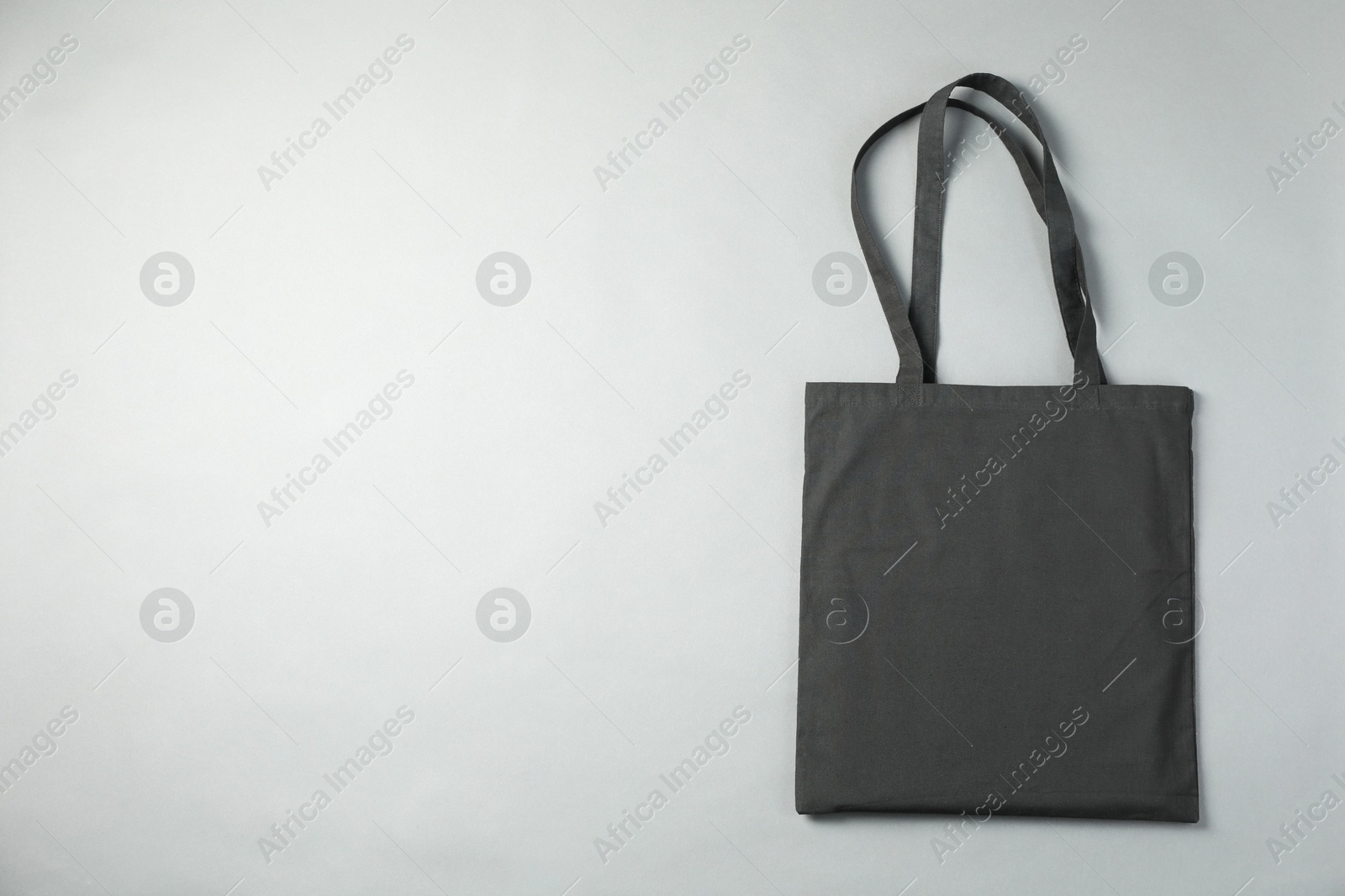 Photo of One shopping bag and space for text on grey background, top view. Mockup for design