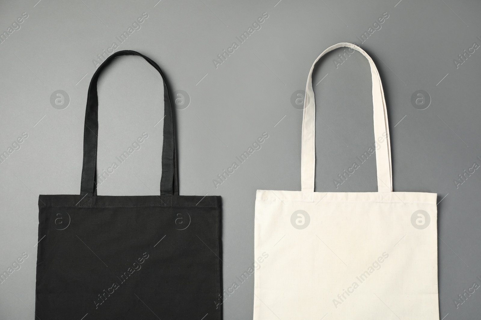 Photo of Shopping bags on grey background, flat lay. Mockup for design