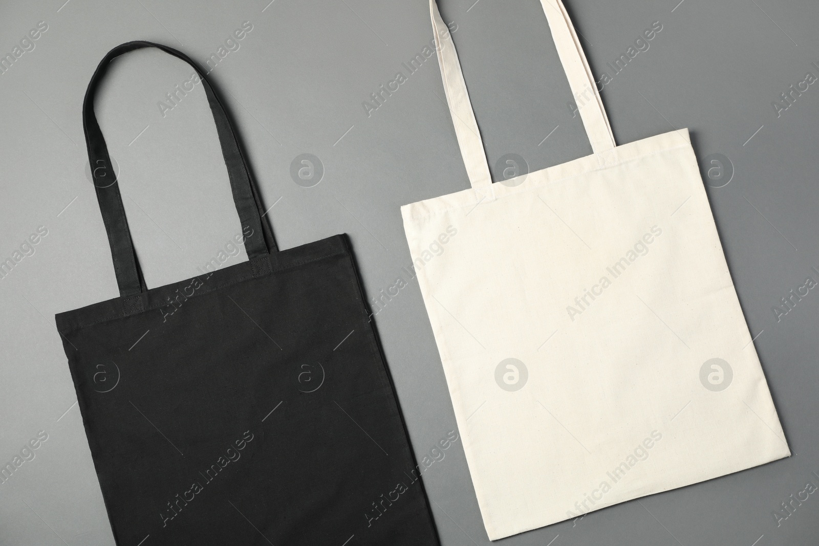 Photo of Shopping bags on grey background, flat lay. Mockup for design