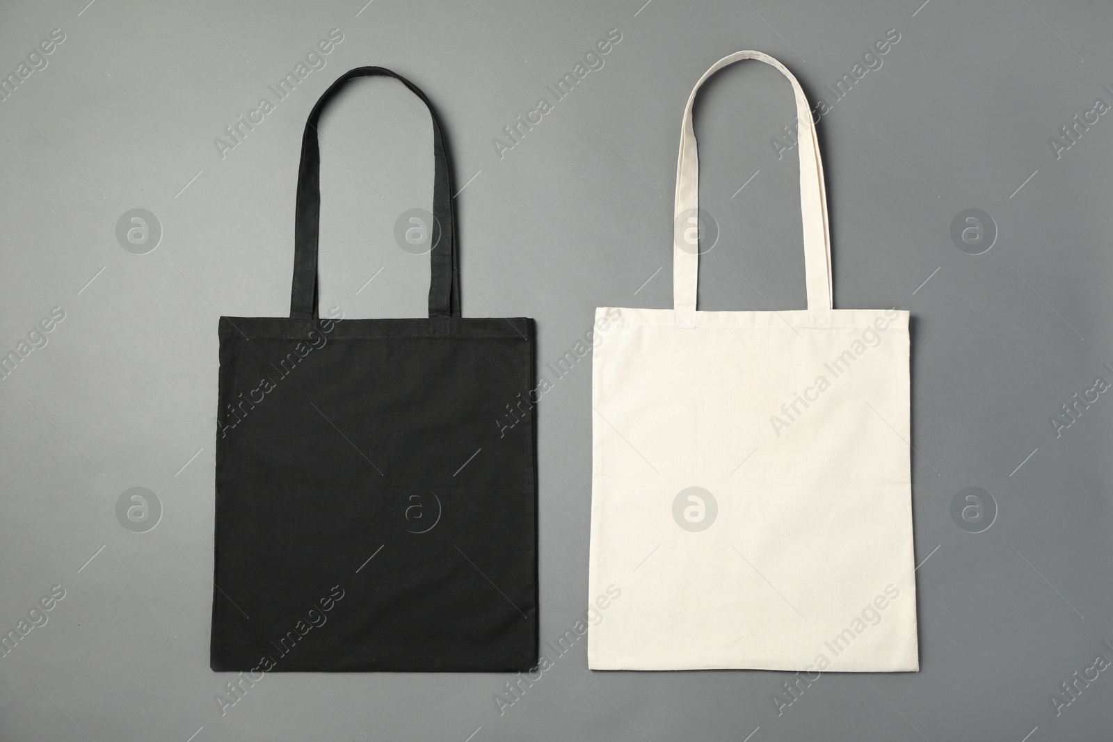 Photo of Shopping bags on grey background, flat lay. Mockup for design