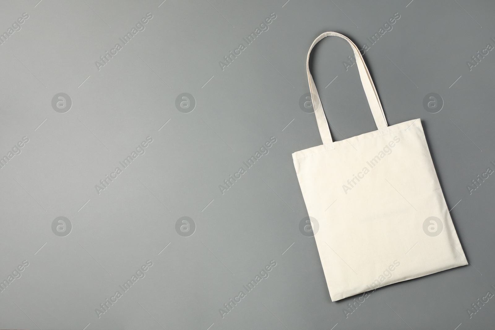 Photo of One shopping bag and space for text on grey background, top view. Mockup for design