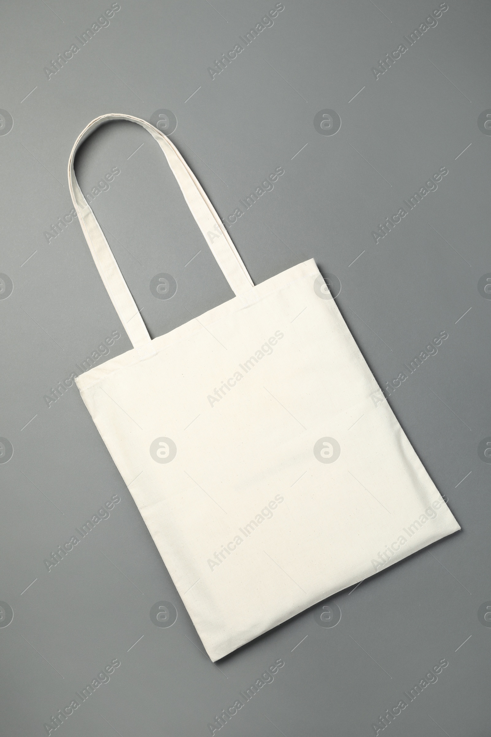 Photo of One shopping bag on grey background, top view. Mockup for design