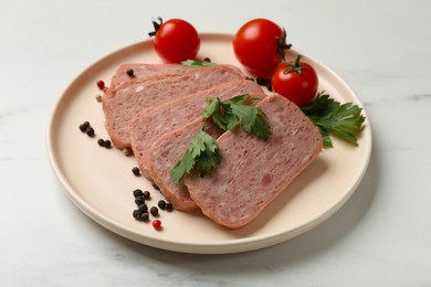 Photo of Pieces of tasty canned meat, parsley, peppercorns and tomatoes on white table, closeup