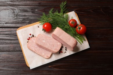 Photo of Pieces of tasty canned meat, tomatoes, dill and peppercorns on wooden table, top view