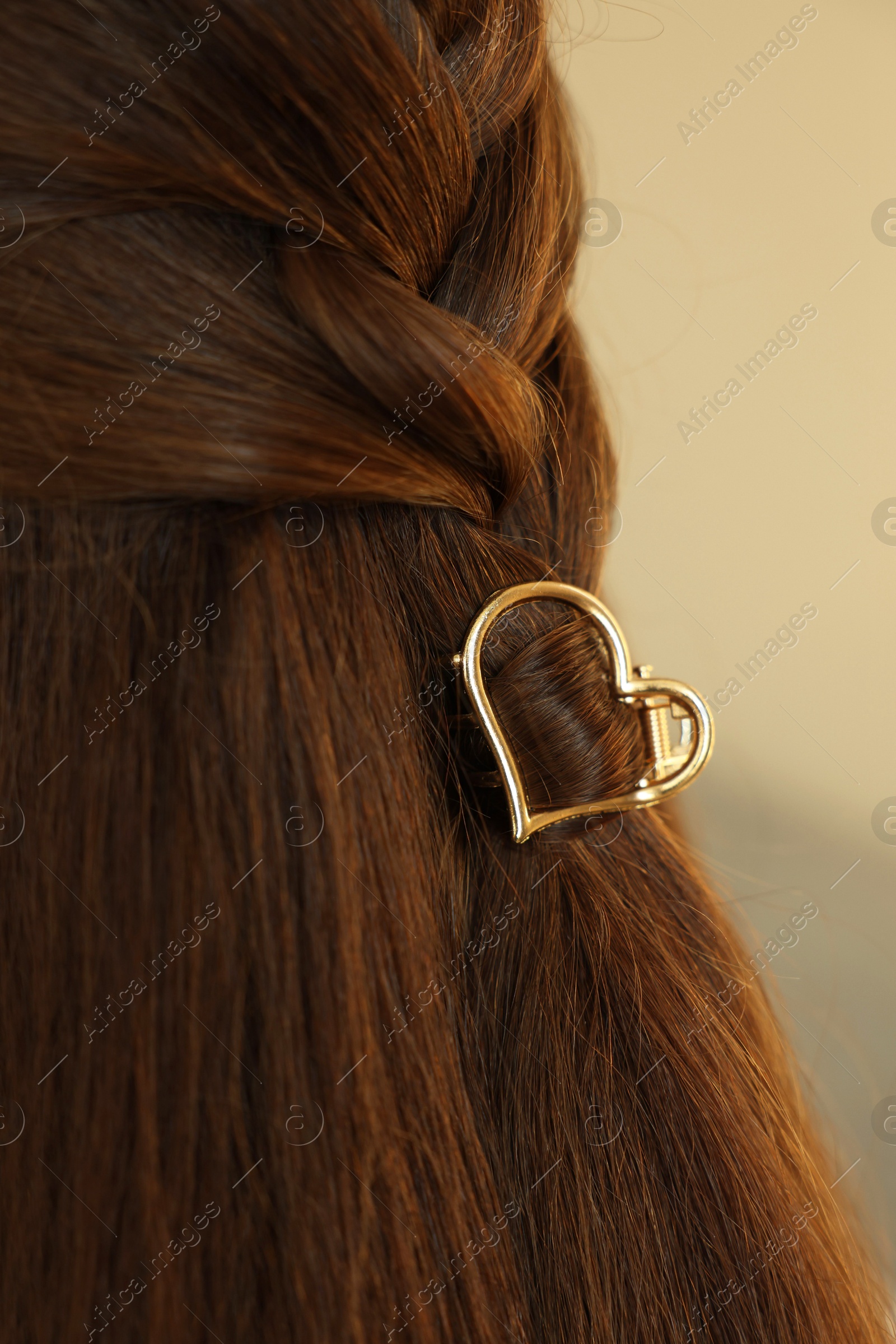 Photo of Teenage girl with stylish hair clip on blurred background, closeup