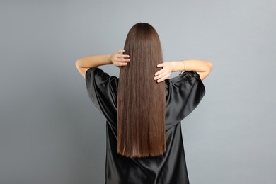 Photo of Teenage girl with healthy long hair on light grey background, back view