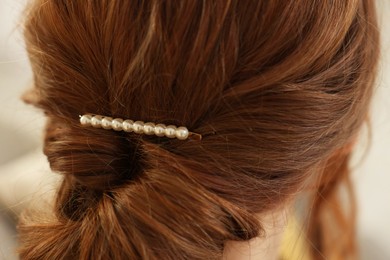 Photo of Teenage girl with stylish hair clip indoors, back view