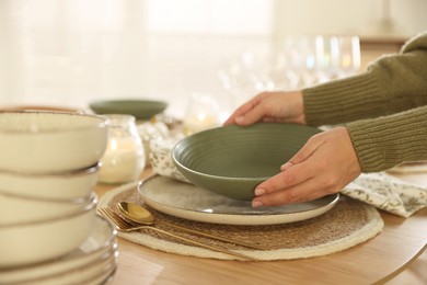 Photo of Woman setting table for dinner at home, closeup