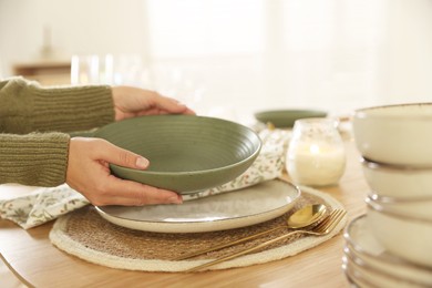 Photo of Woman setting table for dinner at home, closeup