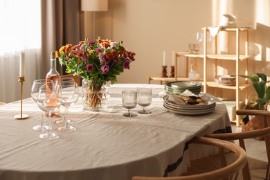 Photo of Stylish table setting with dishware, glasses and beautiful flowers indoors