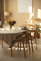 Photo of Stylish table setting with dishware, glasses and beautiful flowers indoors