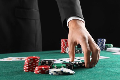 Photo of Man with cards and casino chips playing poker at gambling table, closeup