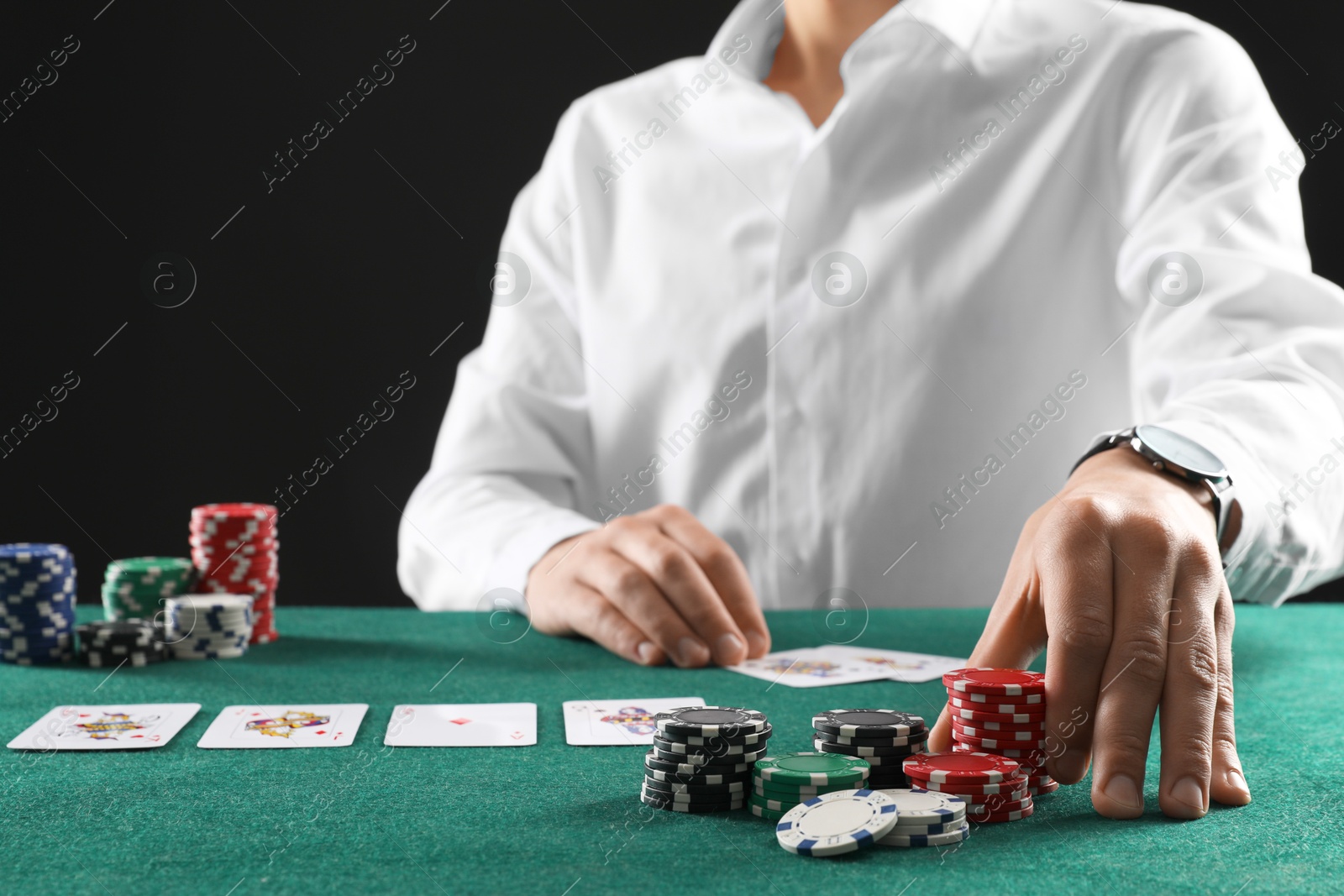 Photo of Man with cards and casino chips playing poker at gambling table, closeup